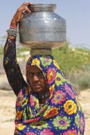 Mujer cargando un recipiente de agua en la cabeza en Bikaner