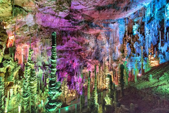 Combinación de luces y colores reflejados sobre las estalagmitas de la cueva